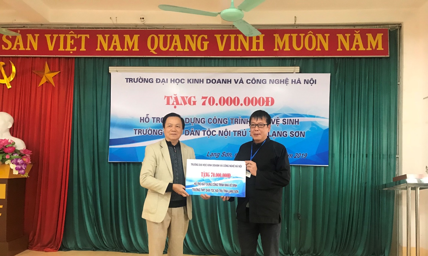 Thay mặt trường THPT Dân tộc nội trú tỉnh Lạng Sơn, Hiệu trưởng Nguyễn Trường Giang nhận quà từ đại diện Công đoàn Trường Đại học Kinh doanh và Công nghệ Hà Nội. (Ảnh: Thương Hiền)